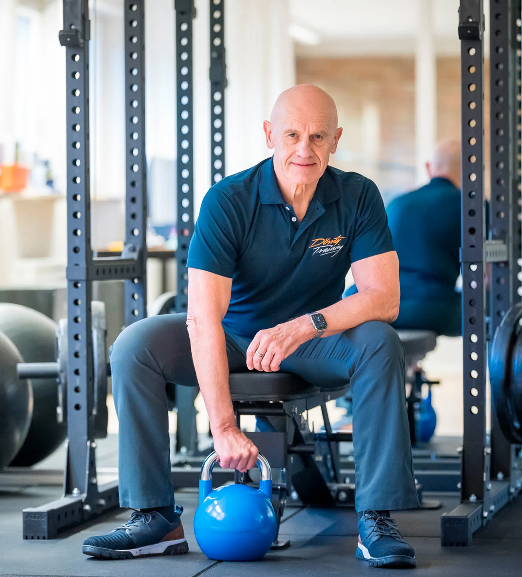 Dr. Michael Dörr sitzt auf einer Hantelbank im Trainingsraum