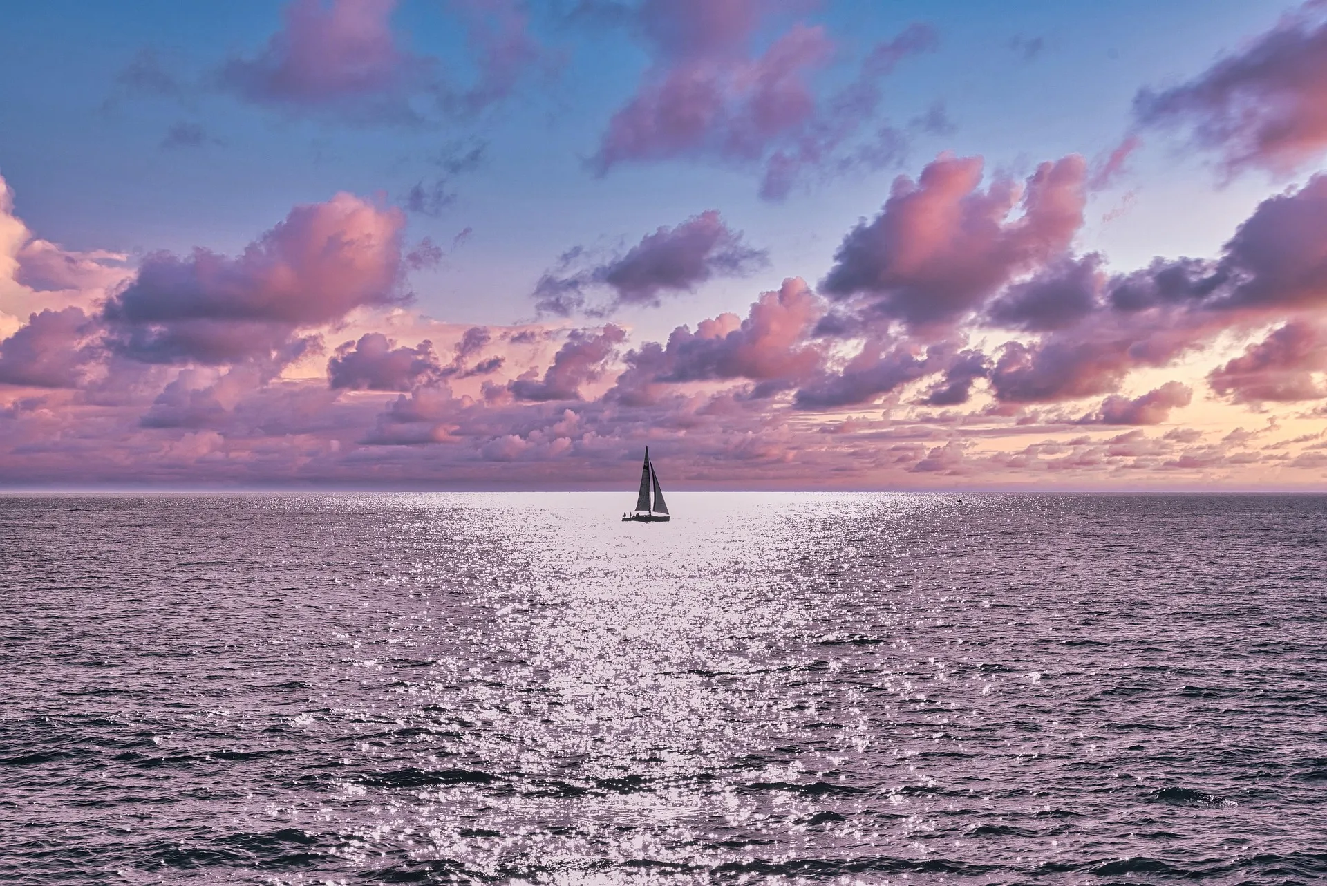 Segelboot auf ruhigem Wasser in der Abenddämmerung