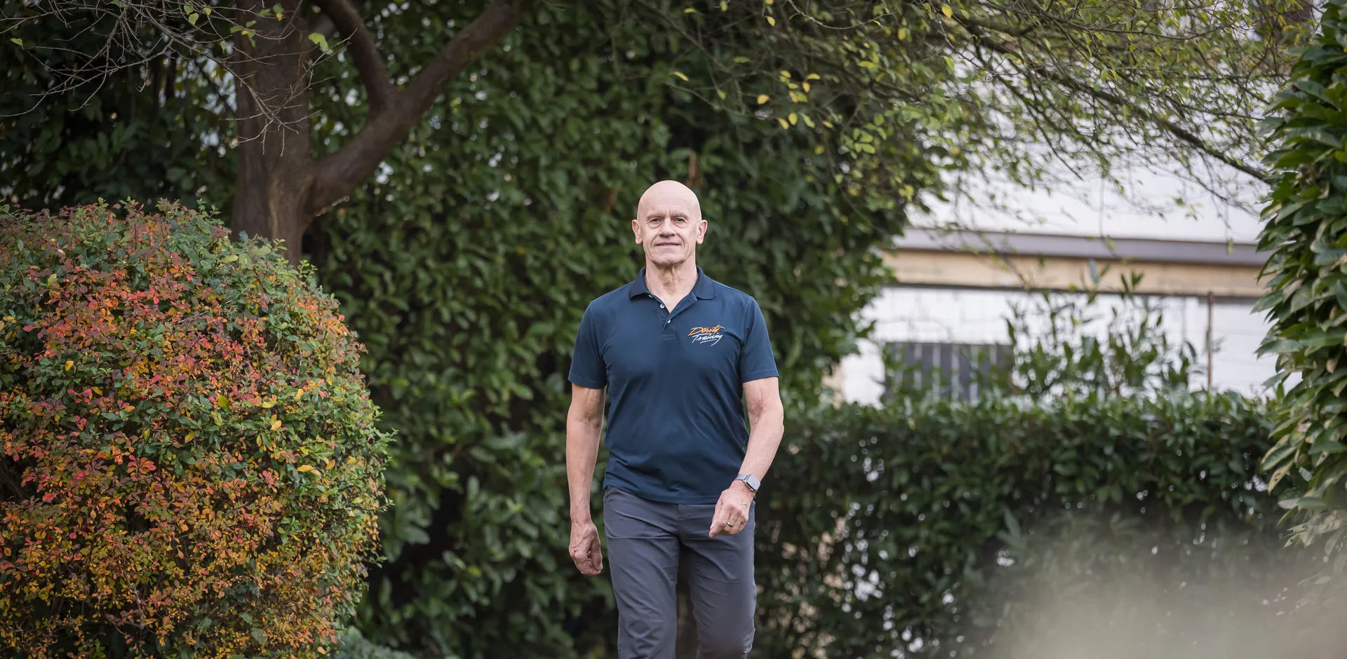 Dr. Michael Dörr geht durch einen begrünten Hof